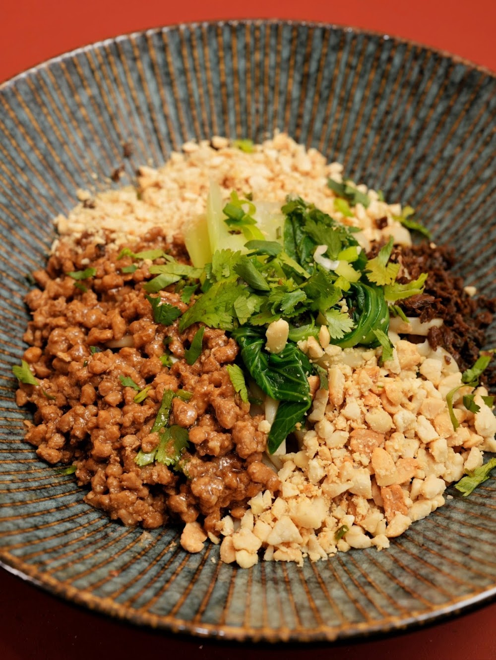 Nouilles dandan avec porc haché, herbes et cacahuètes